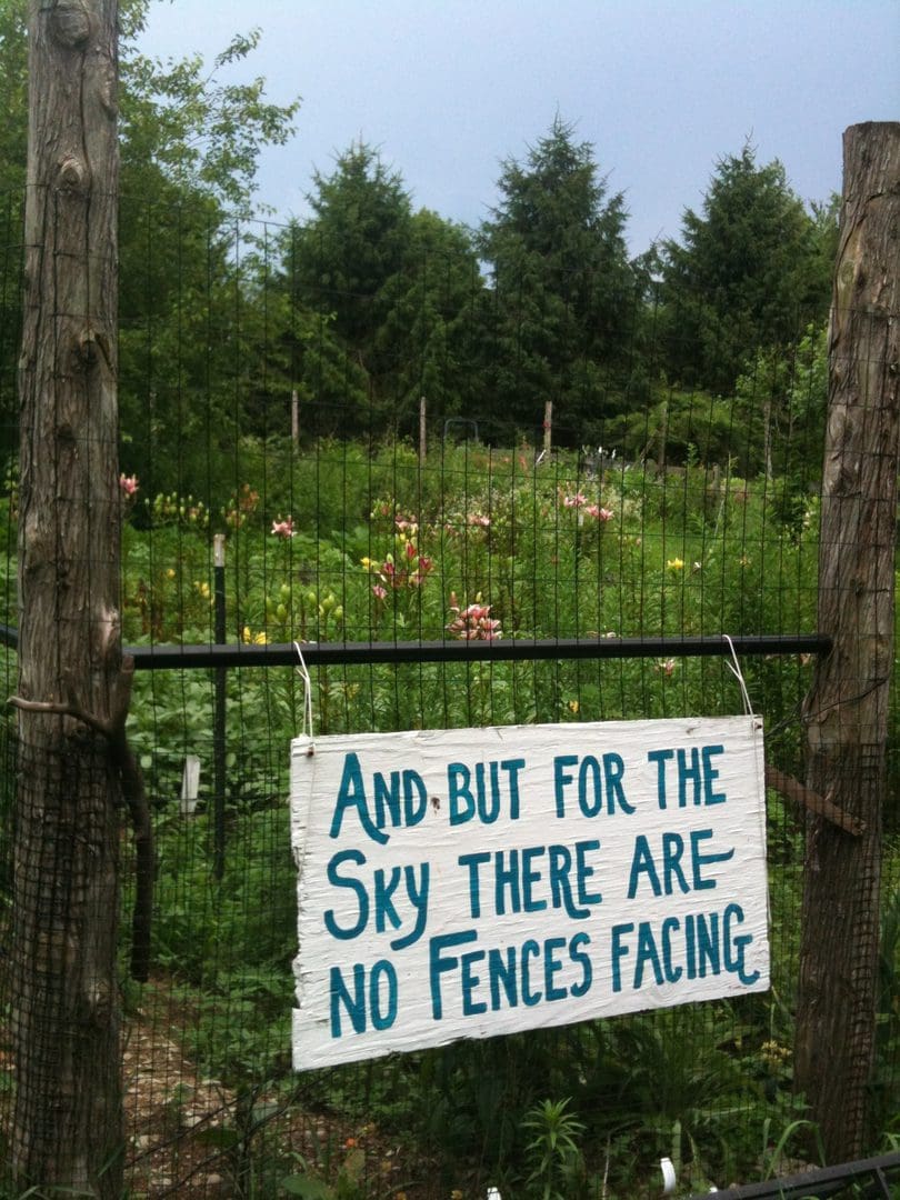 A sign warns that there are no fences facing the property behind a wire fence.