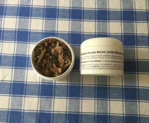 Two containers of rich, creamy chocolate mousse dessert on a blue checkered cloth.