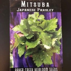 Packet of Mitsuba Japanese Parsley seeds with fresh green leaves.