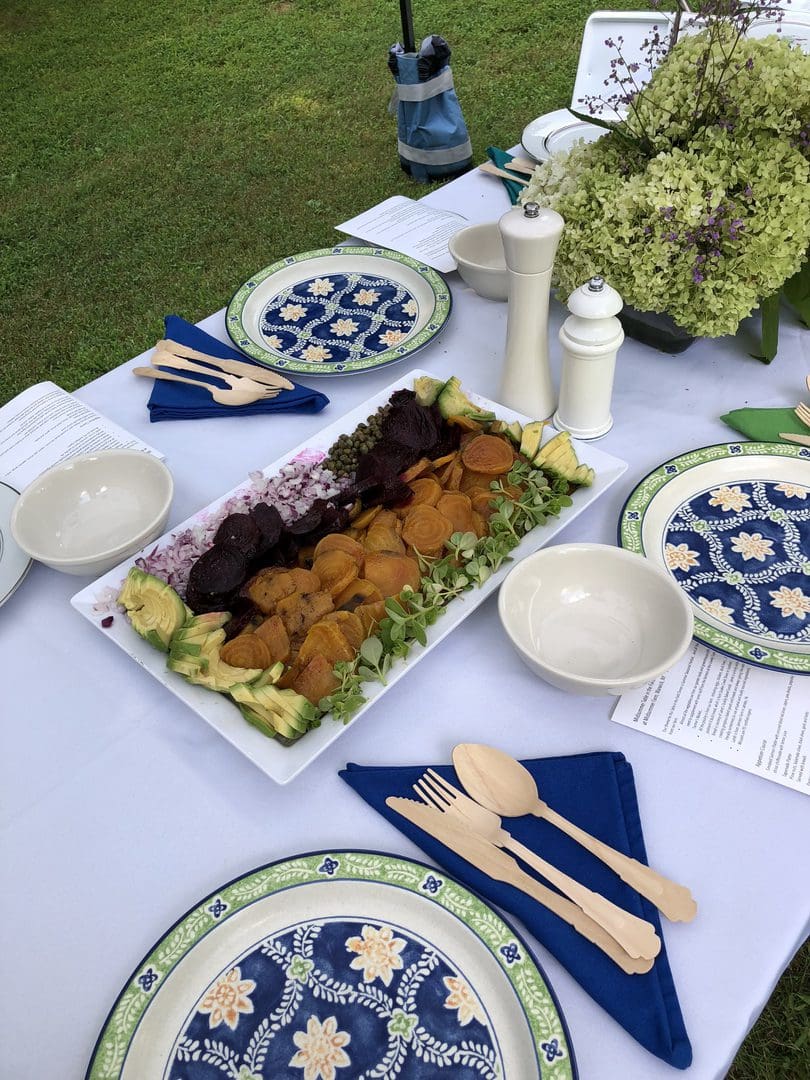 A beautifully arranged outdoor meal with falafel, salad, and decorative plates on a table.