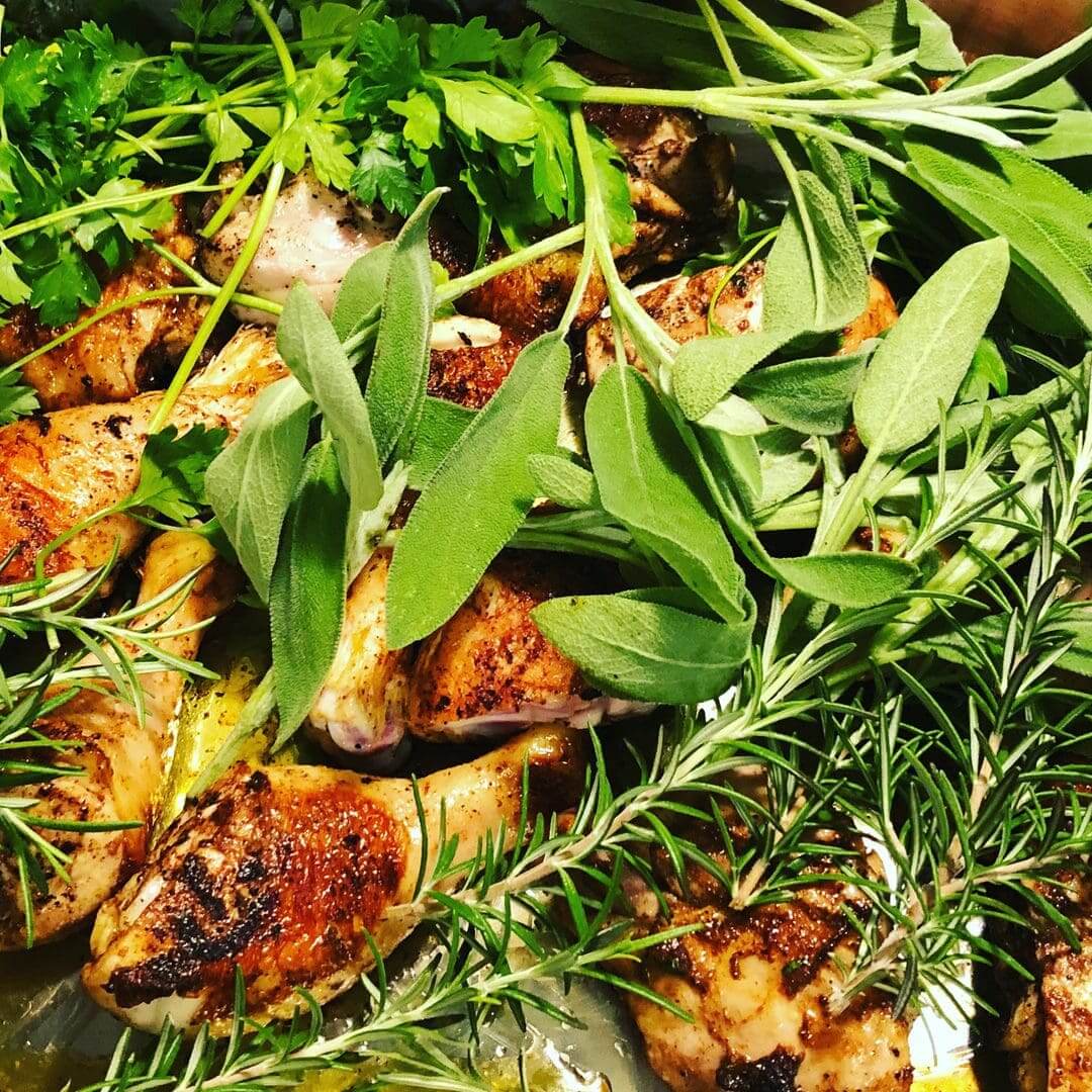 Grilled chicken with fresh herbs like rosemary and sage.