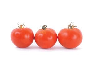 Three ripe red tomatoes with green stems on a white background.