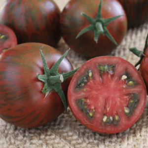 Close-up of ripe, striped tomatoes with one sliced open showing interior.