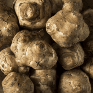Close-up of a pile of Jerusalem artichokes with earthy textures.
