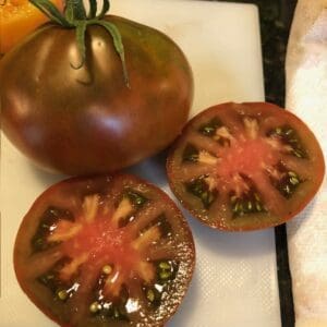 Heirloom tomatoes, one whole and one sliced to show colorful interior.