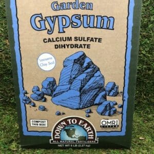 Box of prilled garden gypsum fertilizer on grass