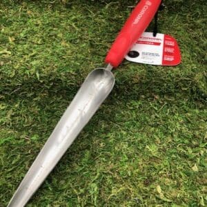 Red-handled metal garden bulb planter on grass