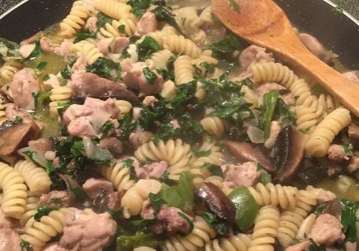 Fusilli pasta with chicken and green vegetables in a creamy sauce.