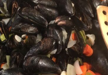 Cooked mussels with chopped carrots and onions